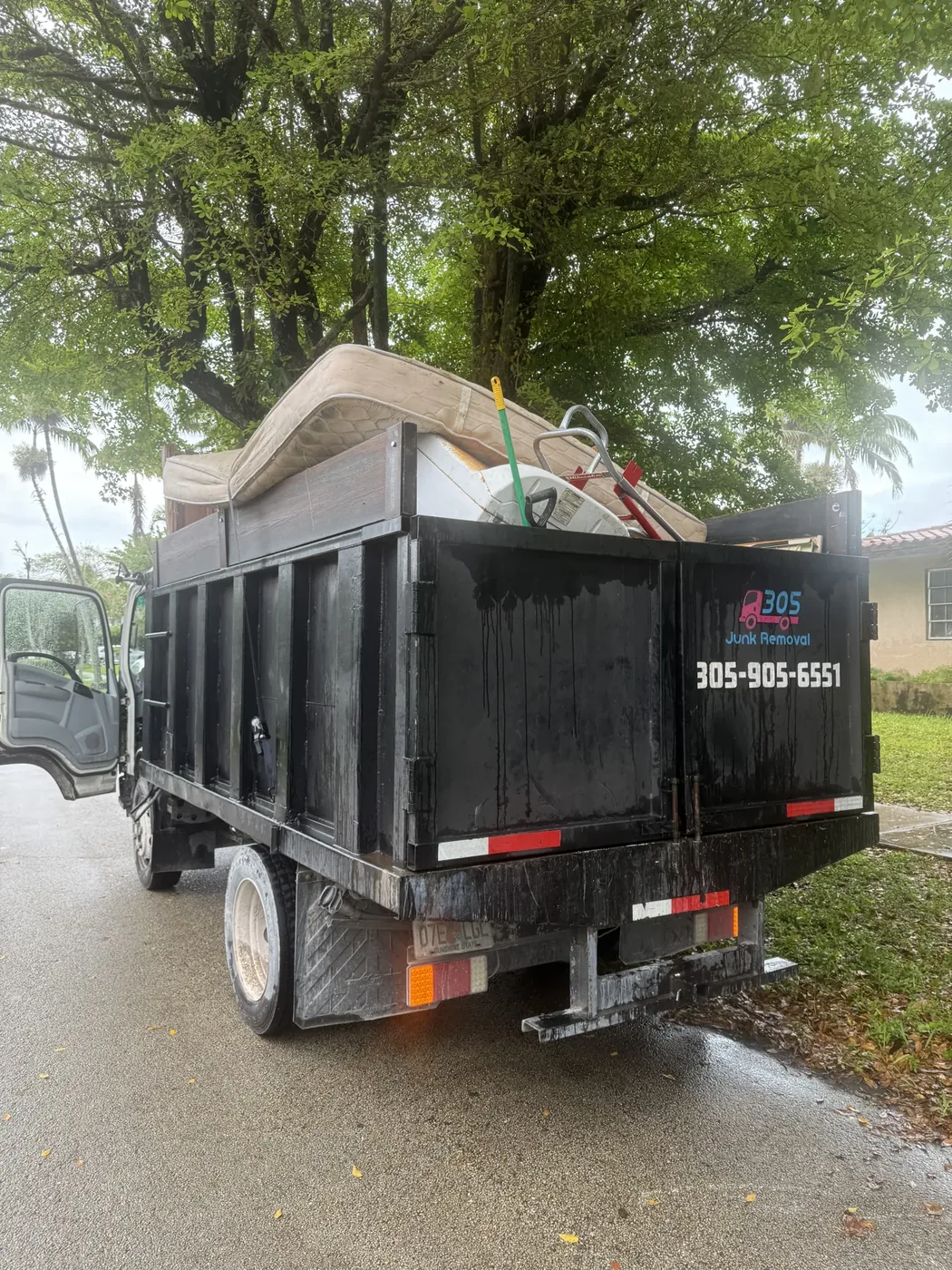 Bulky furniture and a mattress loaded in a 305 Junk Removal truck